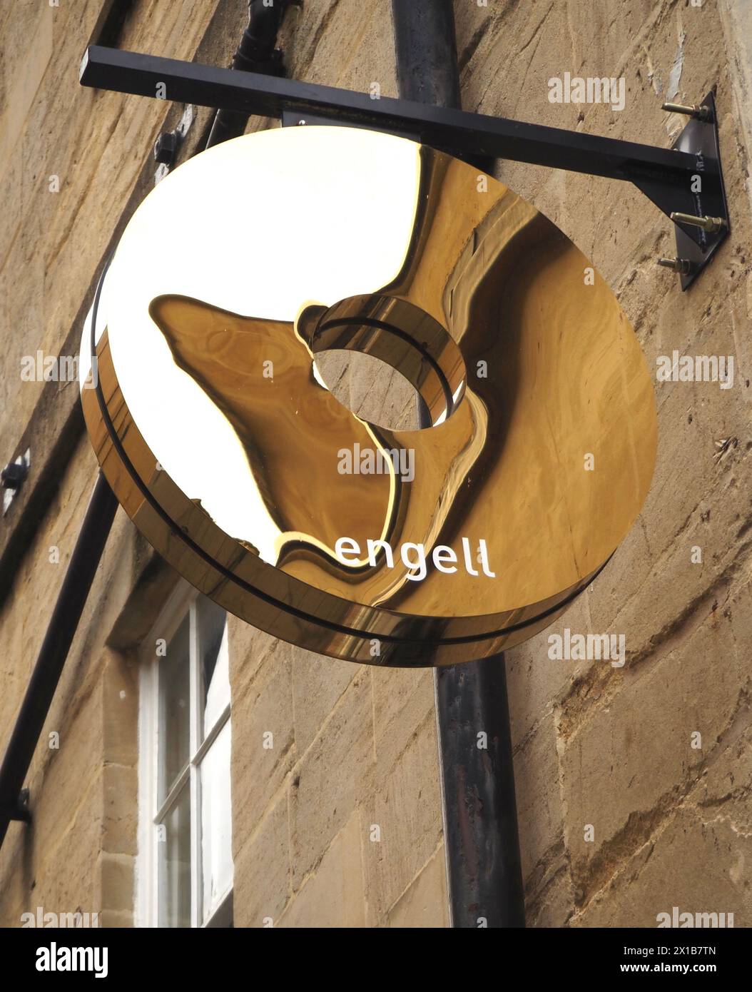 Simbolo dell'anello d'oro appeso sopra il negozio di gioielli Tina Engell Bartlett Street, Bath, con riflessi degli edifici in pietra di Bath Foto Stock
