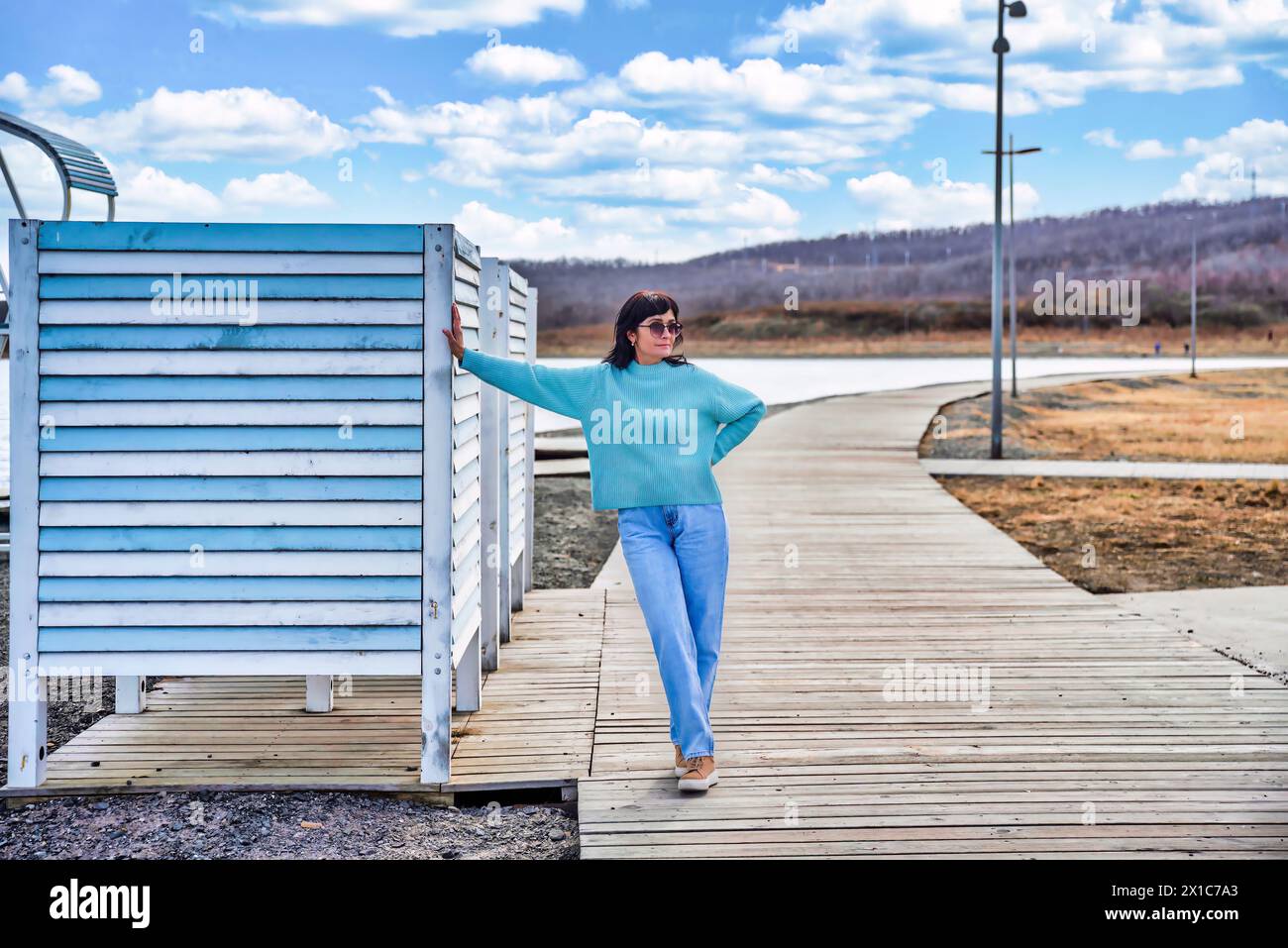 Donna russa di 49 anni in maglione blu in un primo giorno di primavera contro il mare giapponese Foto Stock