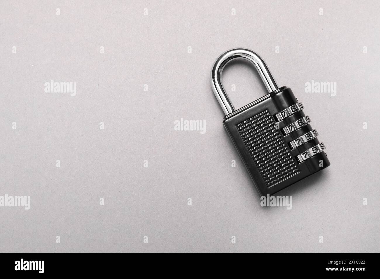 Un lucchetto a combinazione in acciaio su sfondo grigio, vista dall'alto. Spazio per il testo Foto Stock