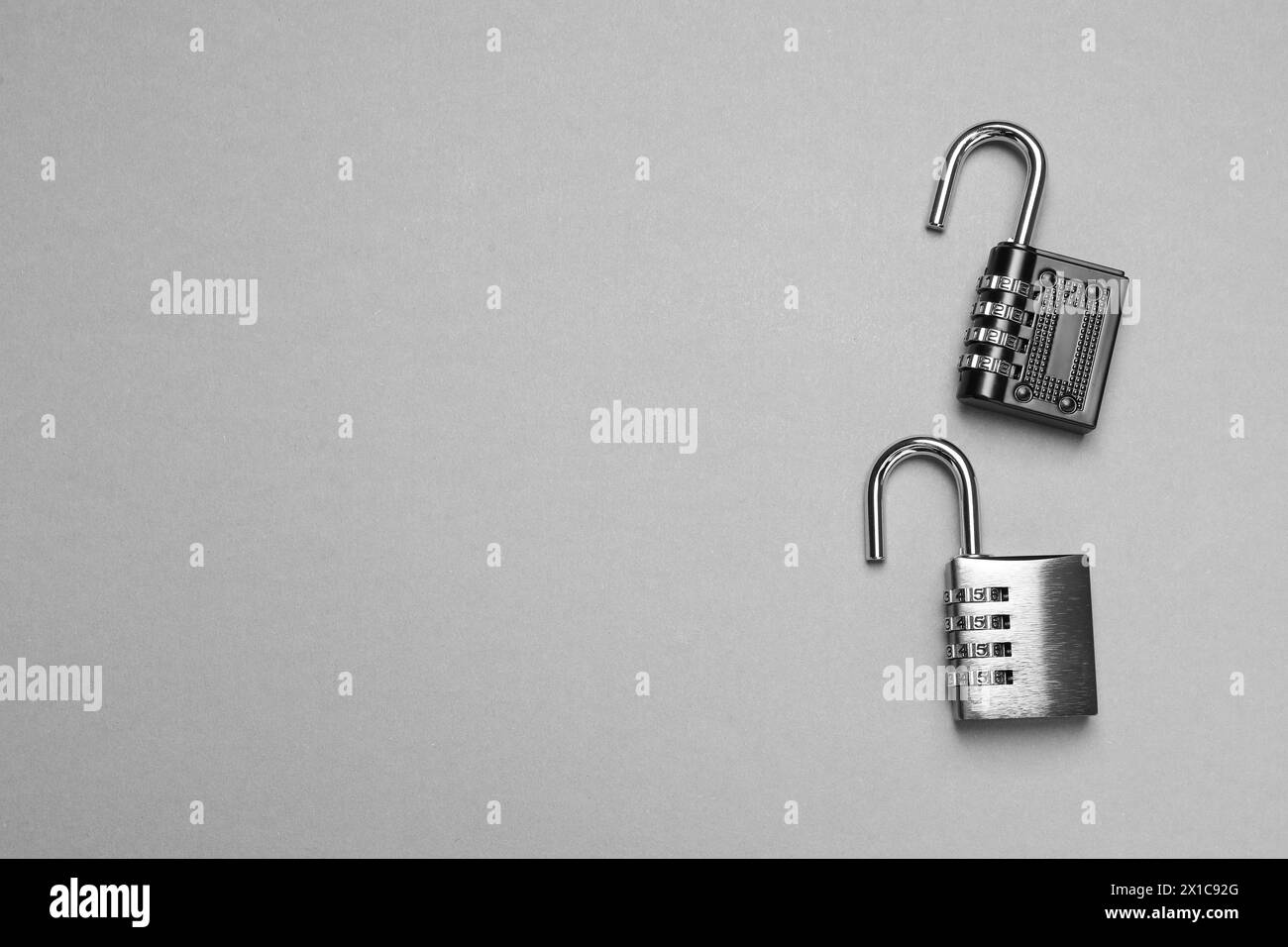 Lucchetti combinati in acciaio su sfondo grigio, vista dall'alto. Spazio per il testo Foto Stock