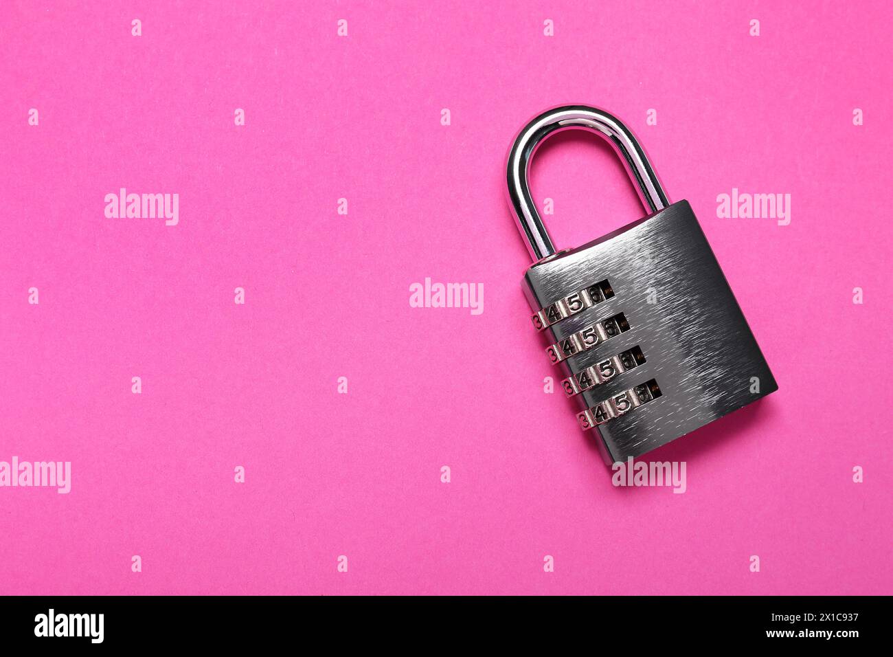 Un lucchetto a combinazione in acciaio su sfondo rosa, vista dall'alto. Spazio per il testo Foto Stock