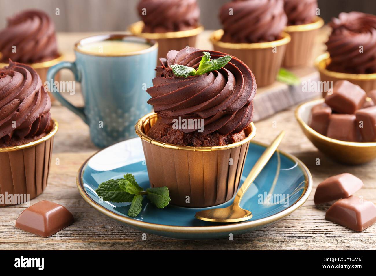 Deliziosi cupcake con pezzi di menta e cioccolato su un tavolo di legno, primo piano Foto Stock