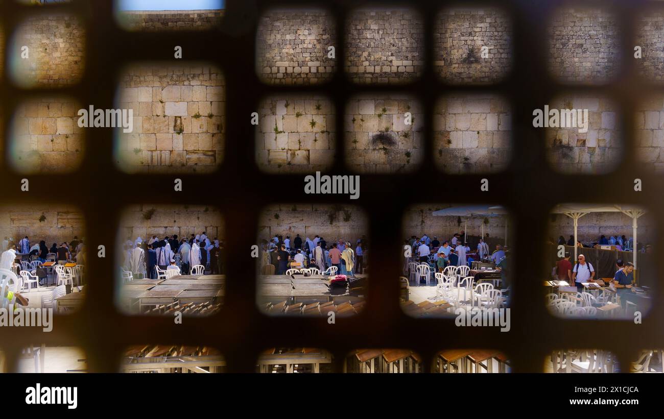 Gerusalemme, Israele - 12 aprile 2024: Scena del muro Occidentale, con la recinzione, e uomini ebrei che pregano, nella città vecchia di Gerusalemme, Israele Foto Stock