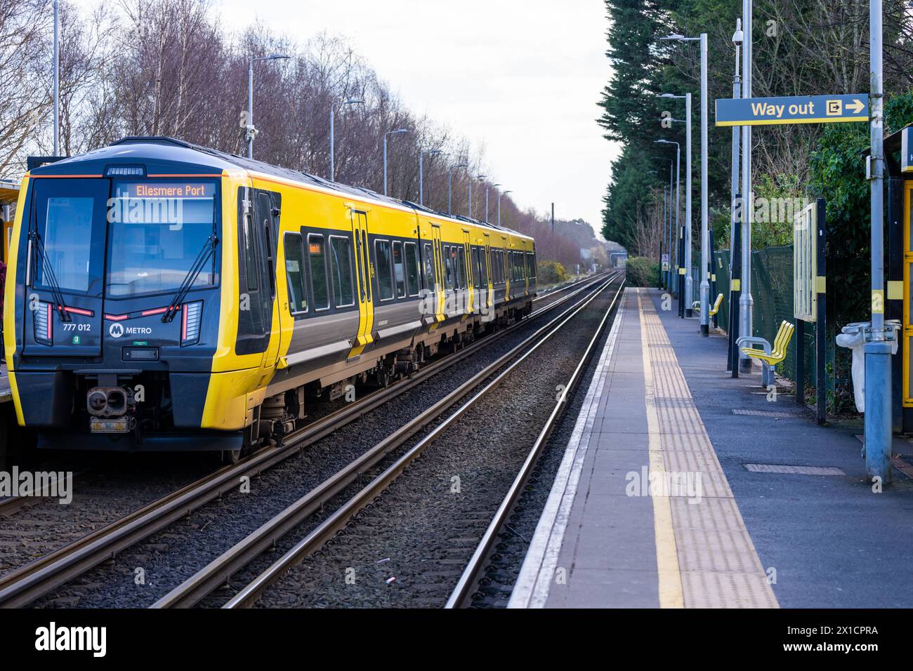 Treno Merseyrail che arriva al binario della stazione Foto Stock