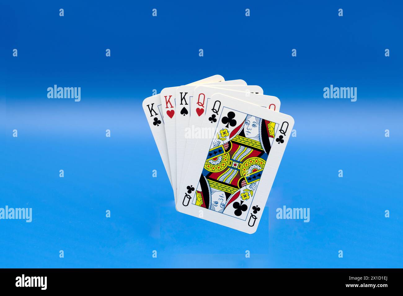 Poker full House realizzato a mano con carte da gioco su sfondo blu, che rappresenta la vittoria, la strategia, il caso e il successo. Foto Stock