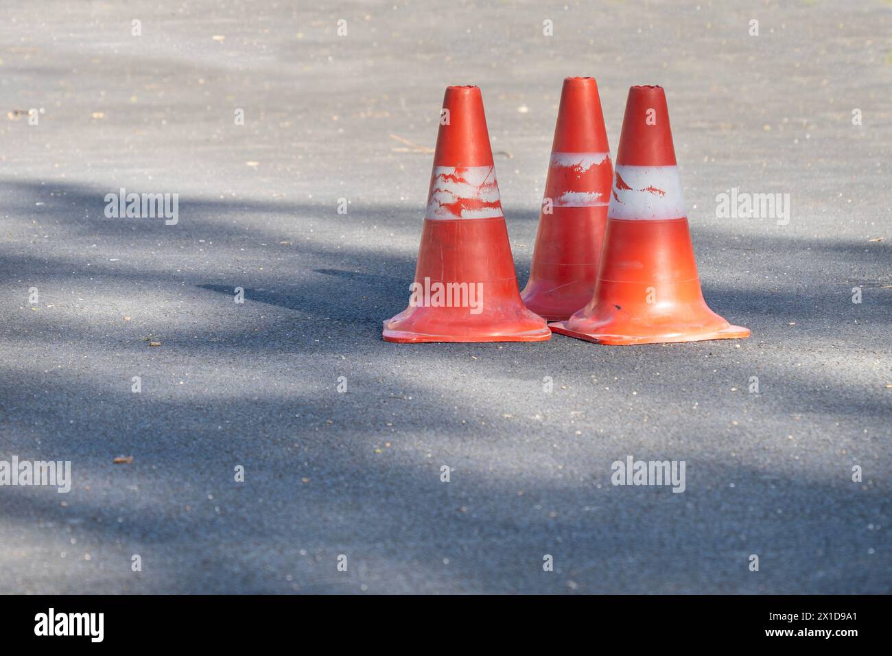 3 boe segnaletiche arancioni su asfalto grigio Foto Stock
