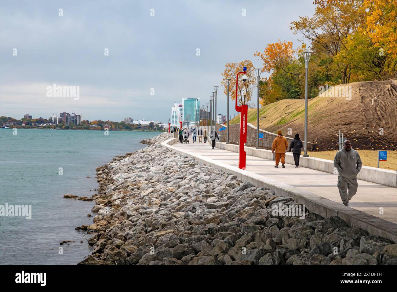 Detroit, Michigan - persone che camminano sul lungofiume di Detroit, sul sito della vecchia fabbrica di pneumatici Uniroyal. Foto Stock