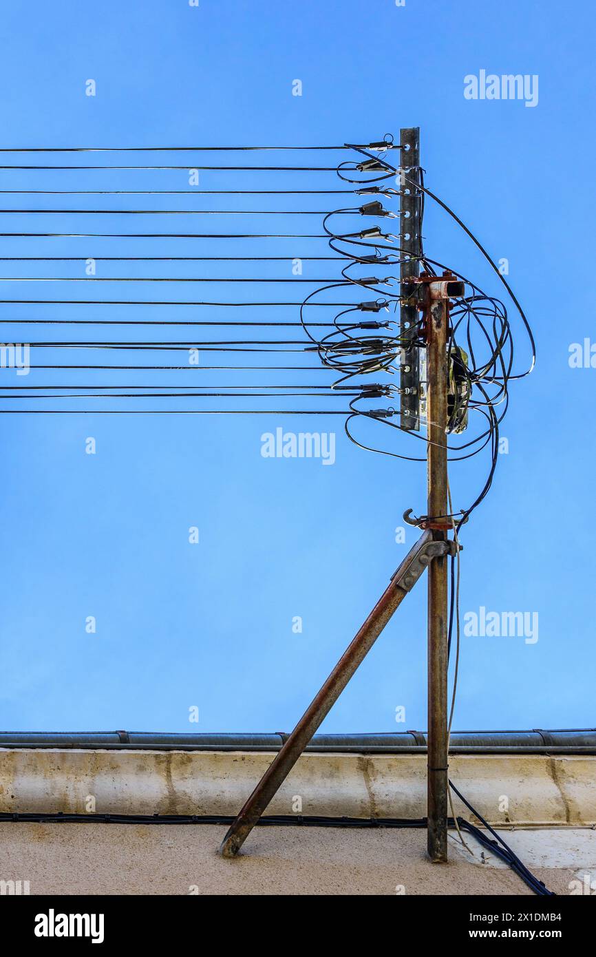 Nuovi cavi in fibra ottica per Internet ad alta velocità montati su vecchie staffe in metallo lungo la stretta strada cittadina - le Blanc, Indre (36), Francia. Foto Stock