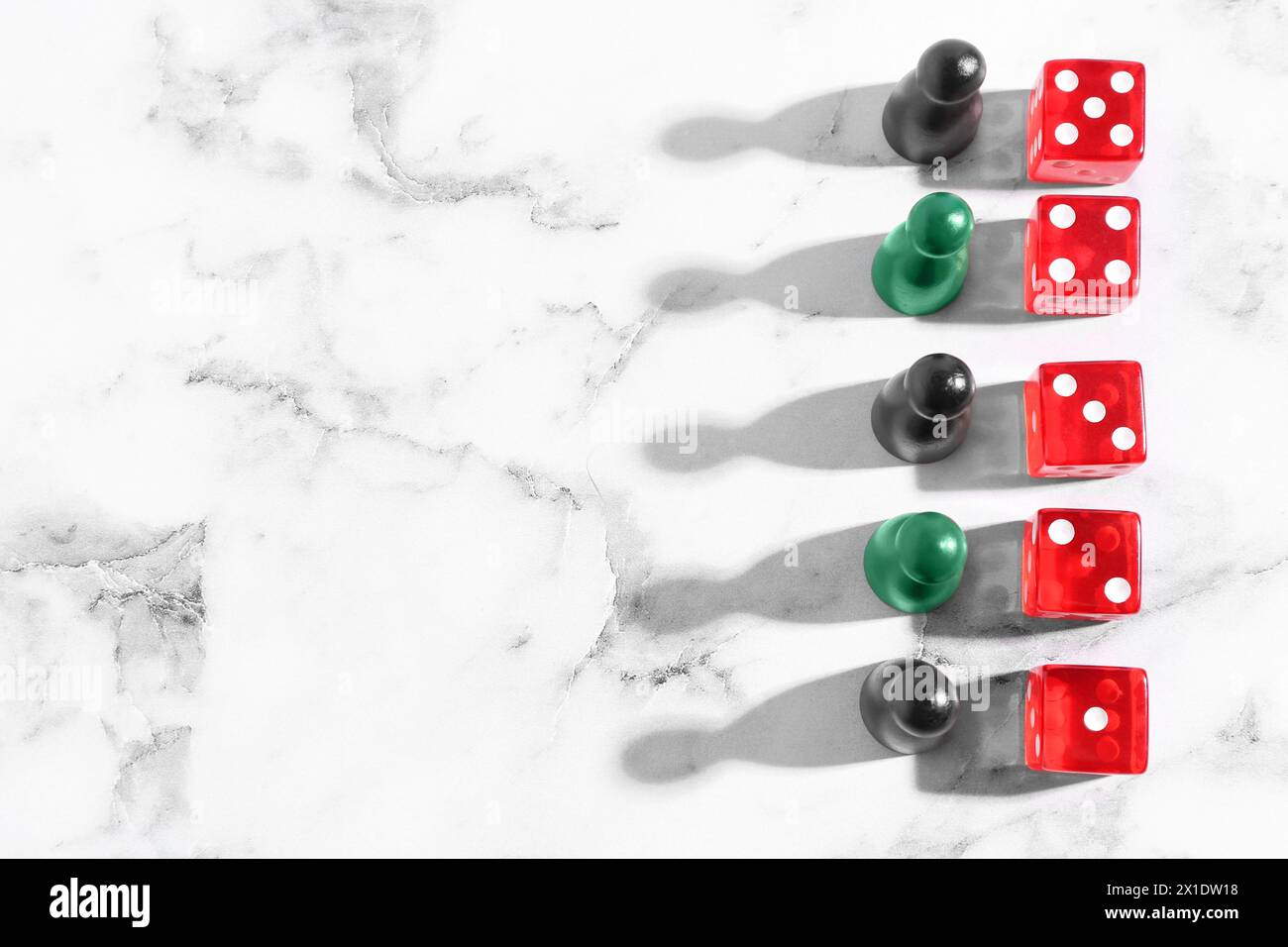 Dadi rossi e pezzi da gioco su tavolo in marmo bianco, piatto. Spazio per il testo Foto Stock