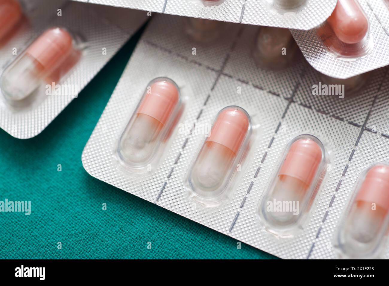 Primo piano di pillole di farmaci in blister su un panno verde Foto Stock