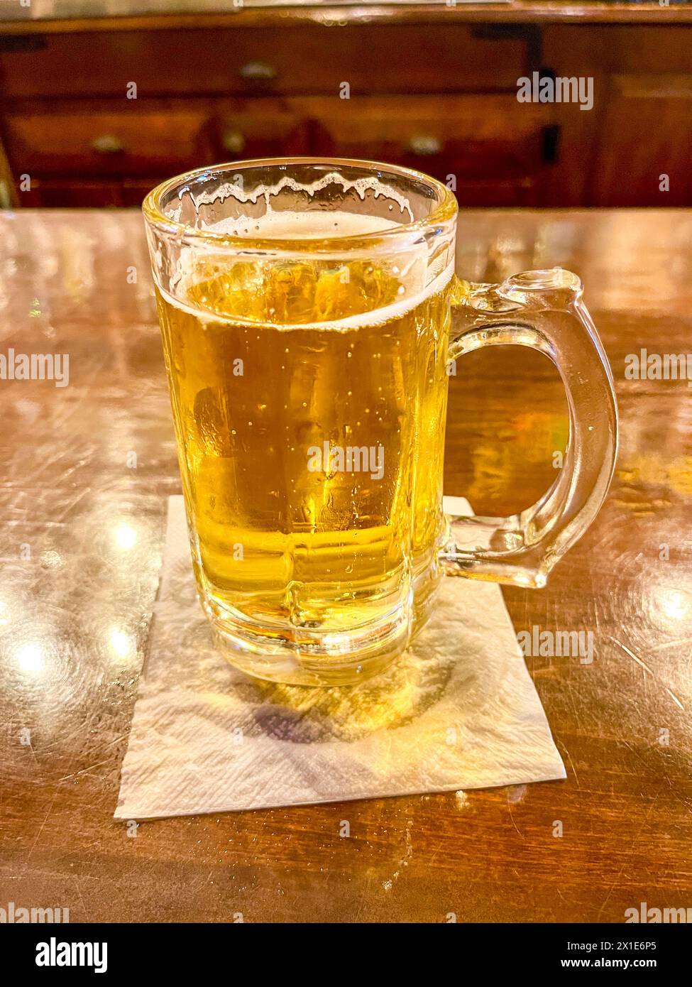Una bella birra ghiacciata in una tazza sul bancone del bar Foto Stock