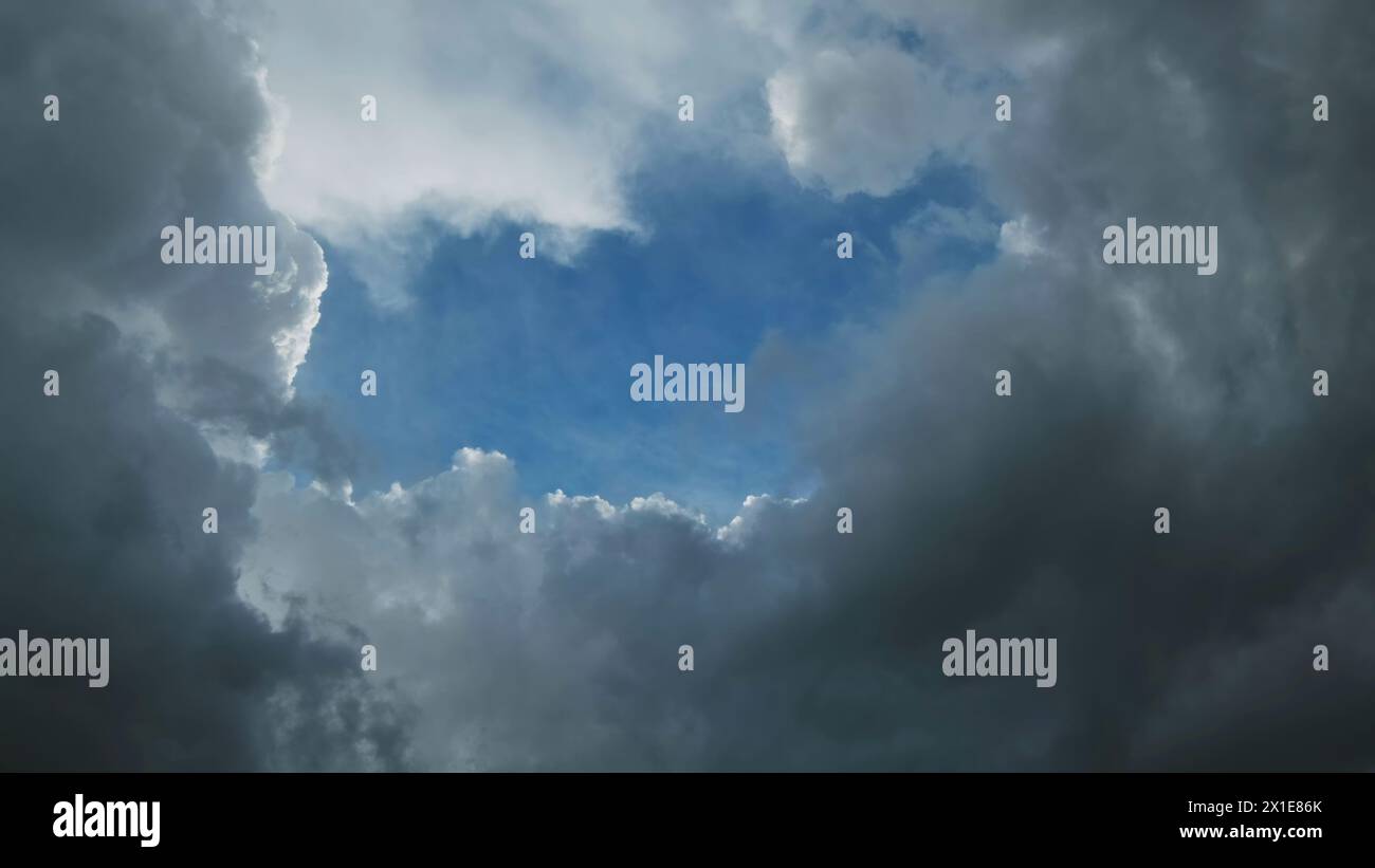 Nuvole di tempesta e buca con il cielo blu Foto Stock