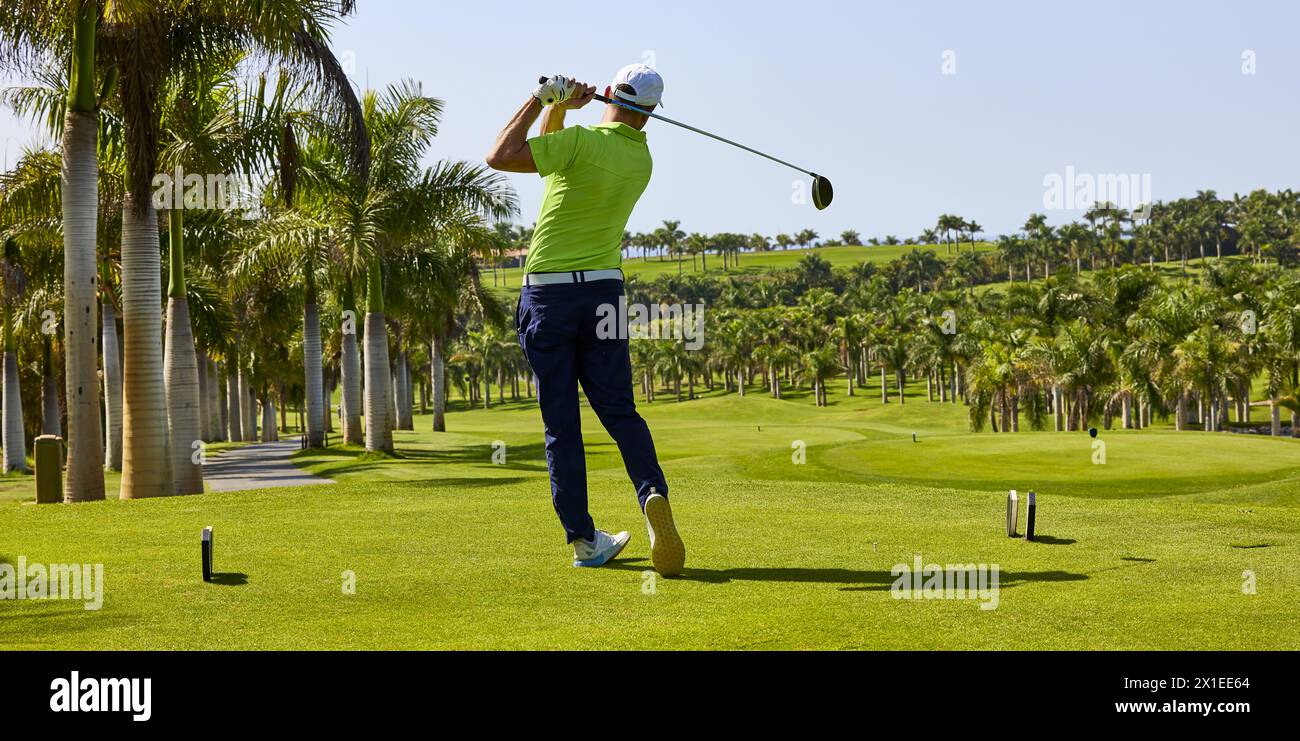 Golfista su un campo da golf, pronto a giocare a golf. Golfista con golf club che colpisce la palla per il tiro perfetto. Foto Stock
