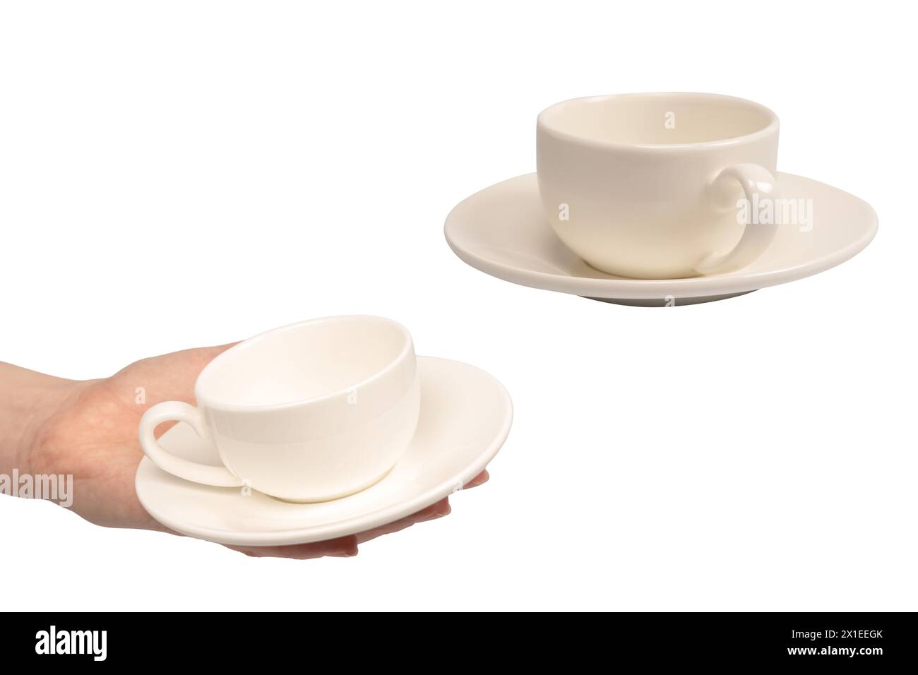 Mano femminile che tiene una tazza di caffè e un piattino isolati su uno sfondo bianco. Foto Stock
