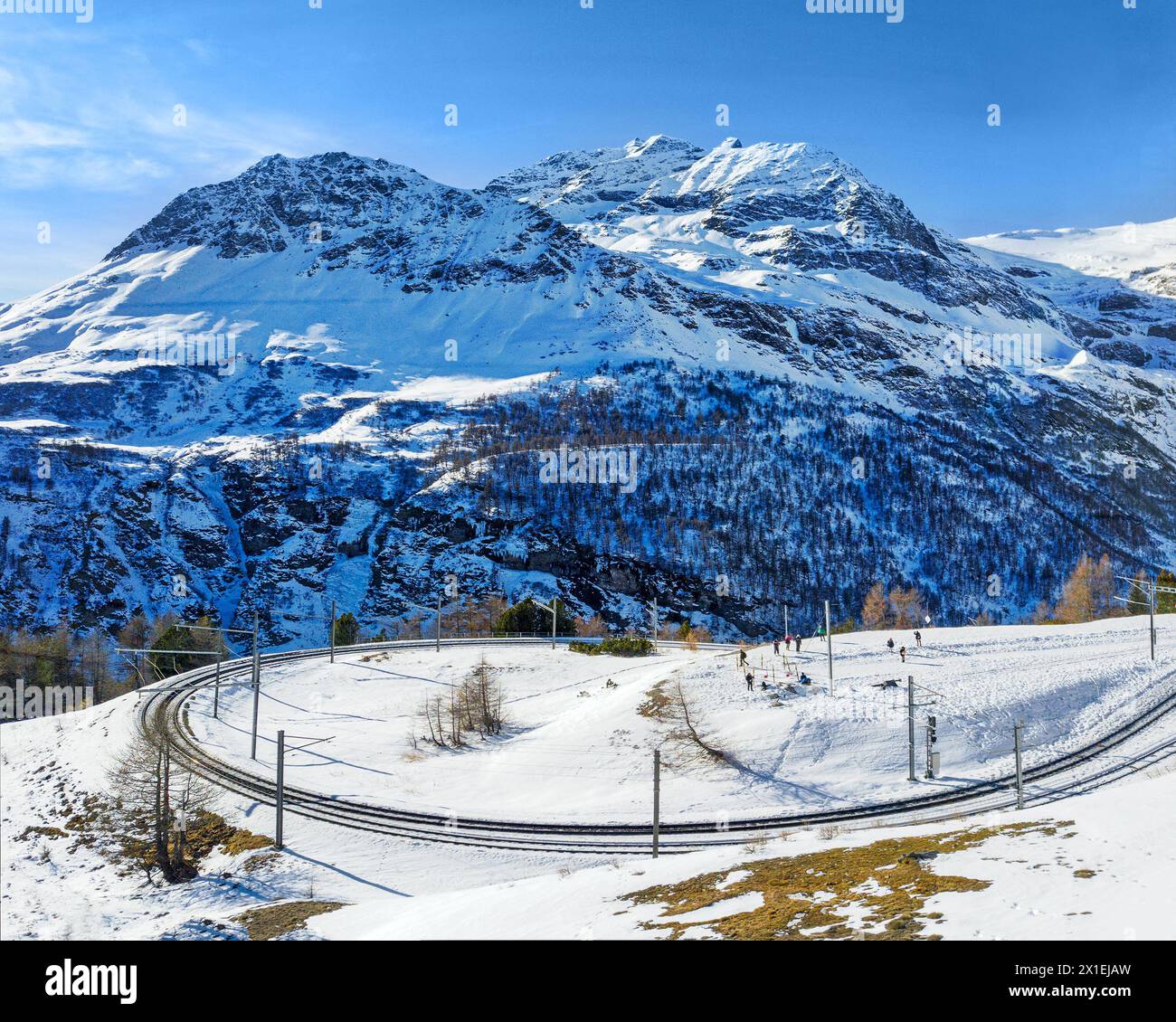 Immagine aerea del tracciato della ferrovia Retica con la famosa curva stretta a 180° sull'alta Alp Grum. Il picco del Piz Palu è sullo sfondo. Foto Stock