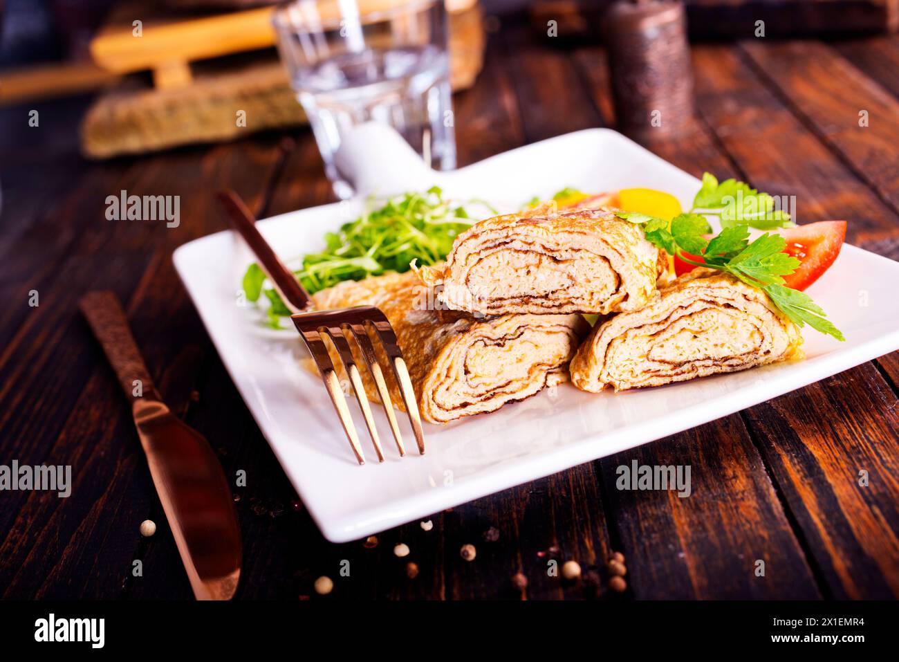 Dashimaki tamago, omelette arrotolate in stile giapponese in piatto su tavola di legno Foto Stock