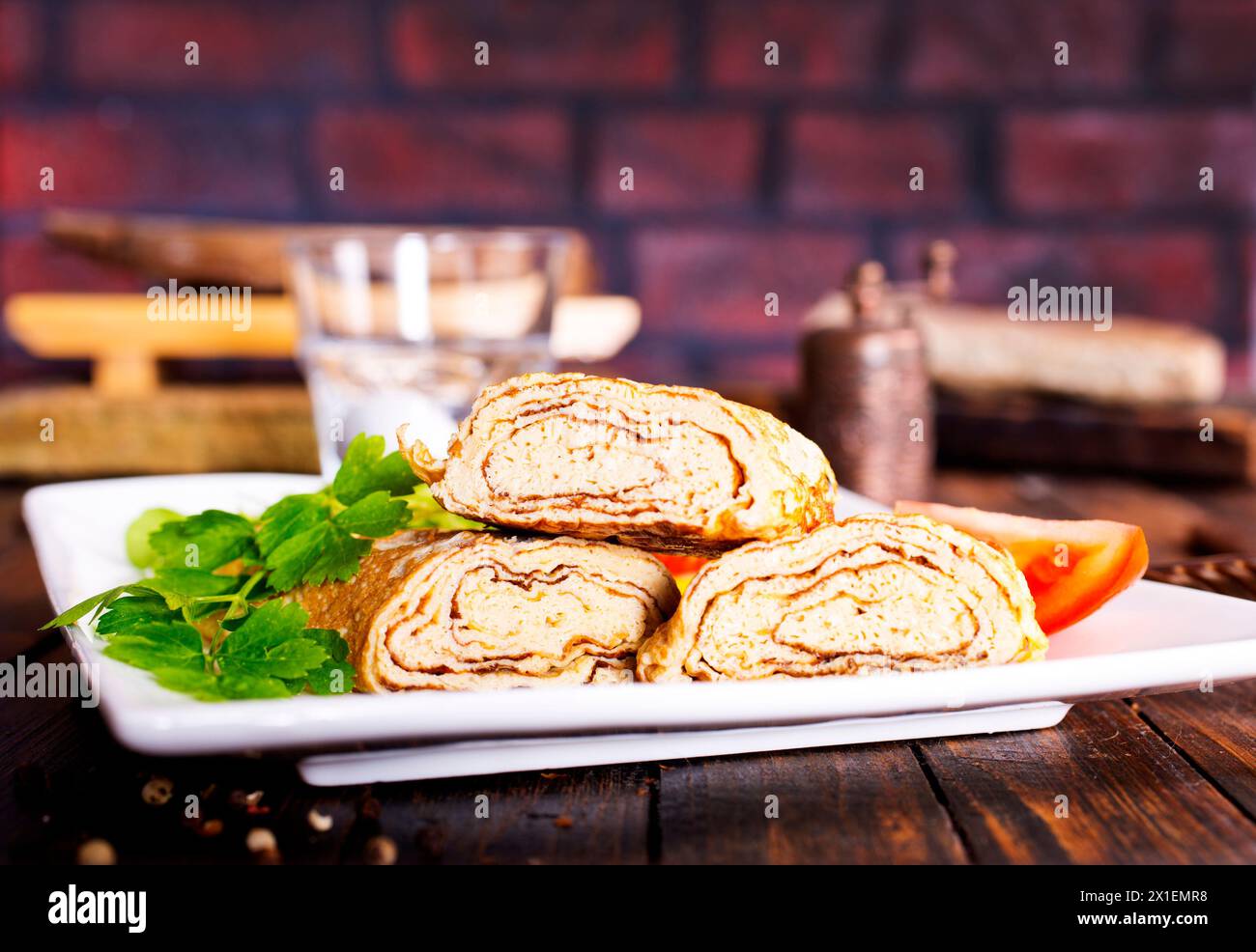 Dashimaki tamago, omelette arrotolate in stile giapponese in piatto su tavola di legno Foto Stock