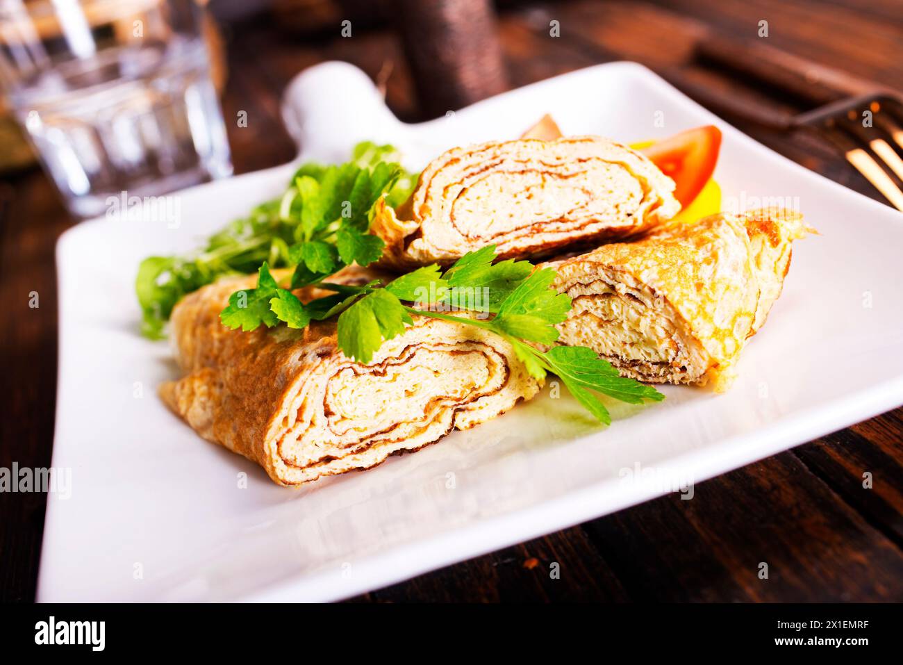 Dashimaki tamago, omelette arrotolate in stile giapponese in piatto su tavola di legno Foto Stock