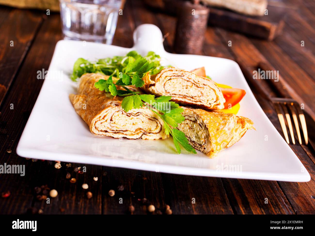 Dashimaki tamago, omelette arrotolate in stile giapponese in piatto su tavola di legno Foto Stock