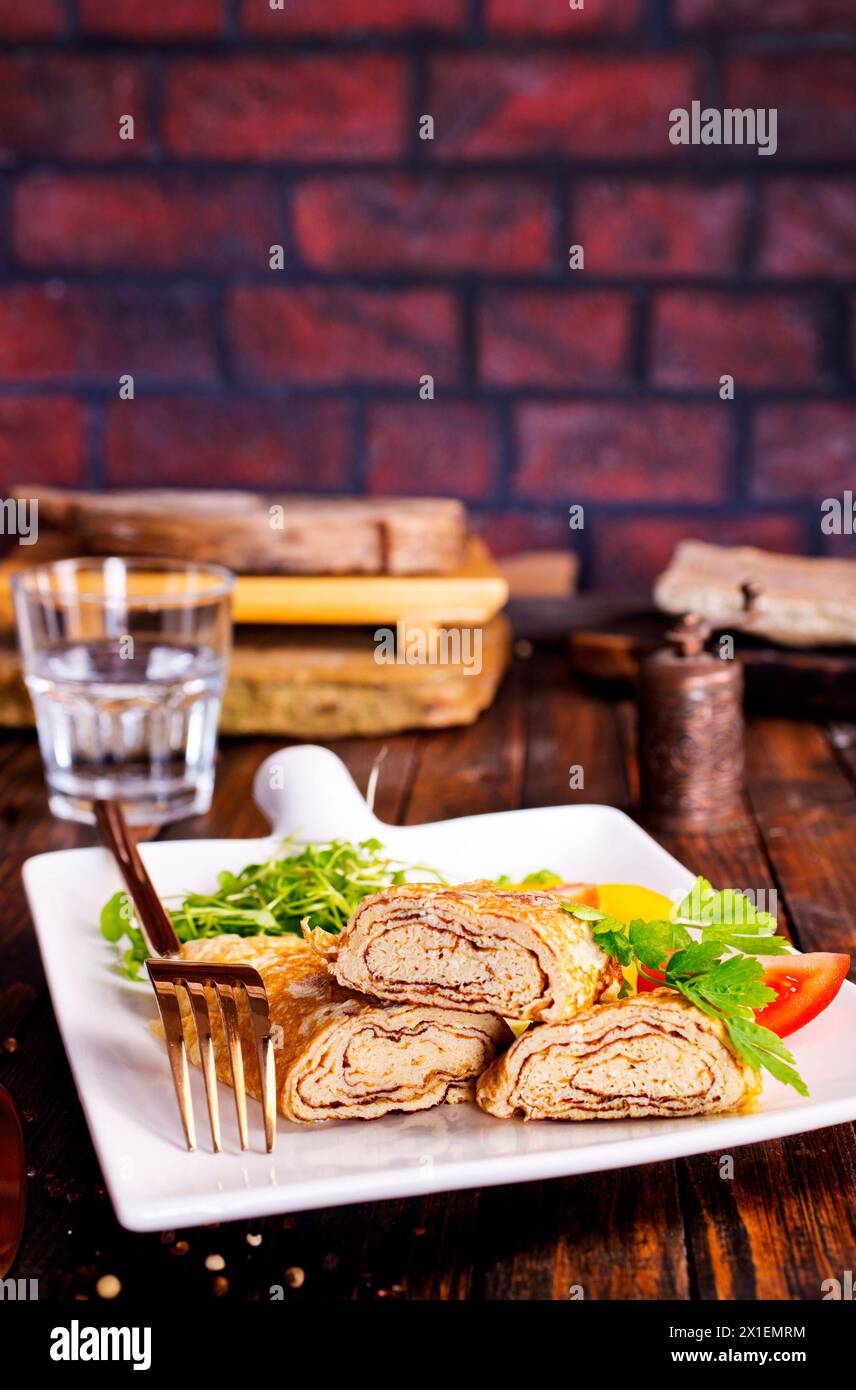 Dashimaki tamago, omelette arrotolate in stile giapponese in piatto su tavola di legno Foto Stock