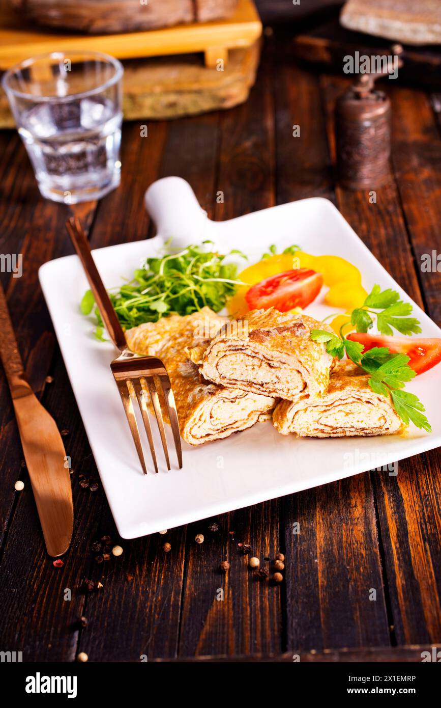 Dashimaki tamago, omelette arrotolate in stile giapponese in piatto su tavola di legno Foto Stock