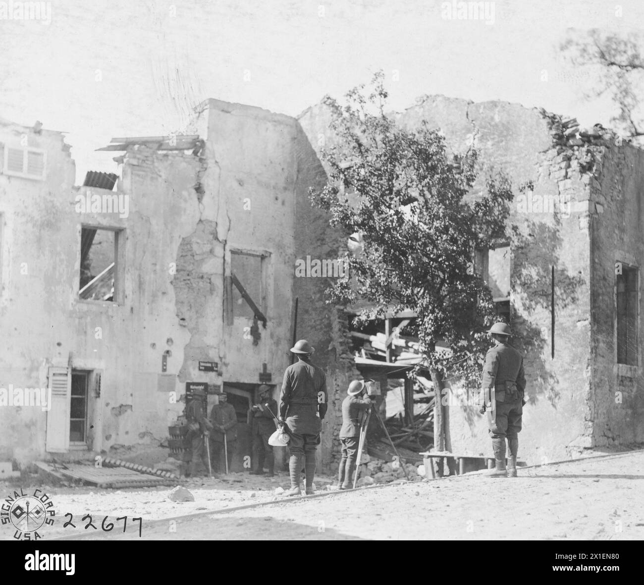 Foto della prima guerra mondiale: (Didascalia originale) Un uomo cinematografico gira un film su un prigioniero di guerra tedesco che arriva in città con una guardia, mostrando anche la distruzione della città da parte del fuoco di artiglieria; Vilsey-sur-Trey, Francia ca. 1918 Foto Stock