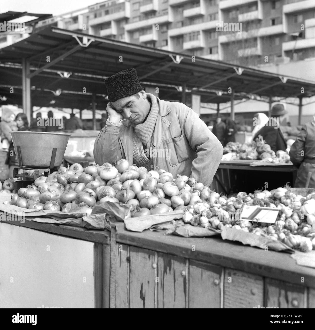 Repubblica Socialista di Romania negli anni '1970 Uomo che vende prodotti in un mercato agricolo della città, aspetta i clienti e si stanca. Foto Stock