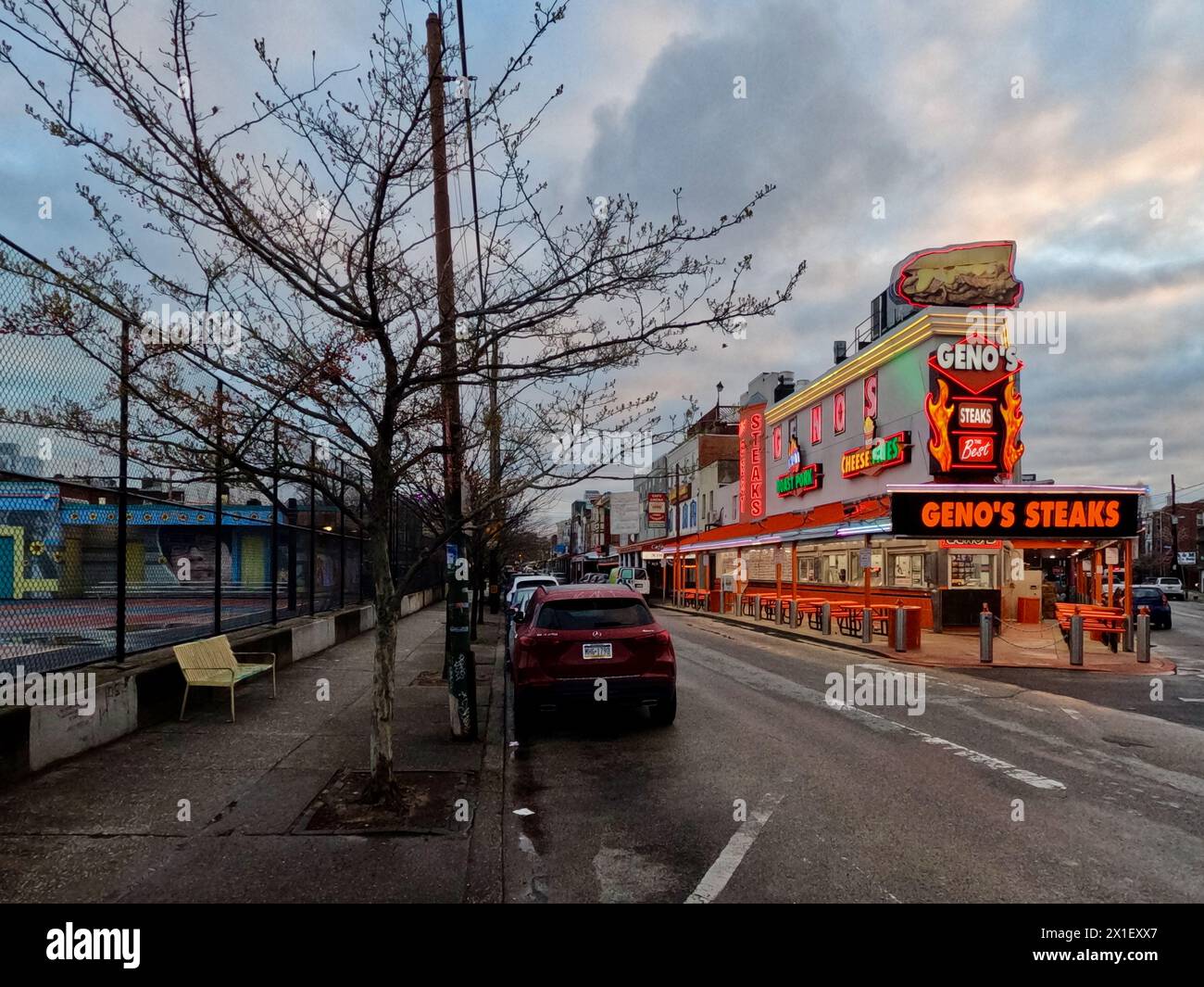 Geno's Steaks, un pilastro del mercato italiano di Filadelfia, si illumina al neon all'alba. Foto Stock