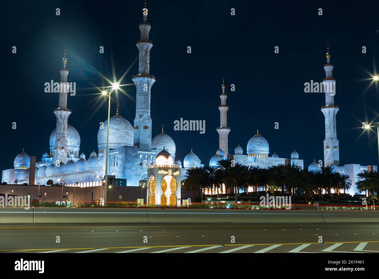 Bellissima Moschea con luci vicino alla strada ad Abu Dhabi di notte Foto Stock