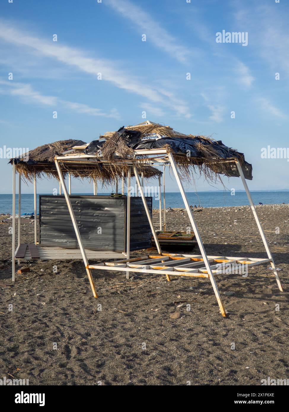 Case decorative abbandonate con tetti di paglia sulla riva del mare. Fuori stagione. Mancanza di turisti. crisi Foto Stock