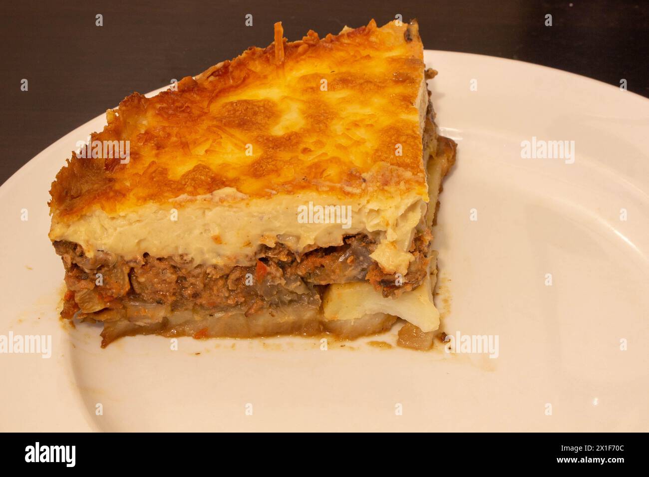 Viziatevi con la ricca tradizione culinaria del Mediterraneo con questo invitante piatto di moussaka. Strati di melanzane teneri, carne macinata salata e c Foto Stock