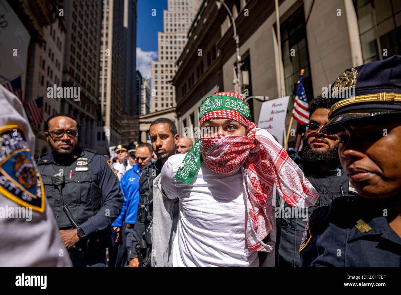 New York, Stati Uniti. 15 aprile 2024. La polizia scorta un uomo ammanettato mentre i manifestanti filo-palestinesi affrontano un piccolo gruppo di manifestanti israeliani durante eventi in competizione al di fuori della Borsa di New York (NYSE) (foto di Michael Nigro/Pacific Press) crediti: Pacific Press Media Production Corp./Alamy Live News Foto Stock