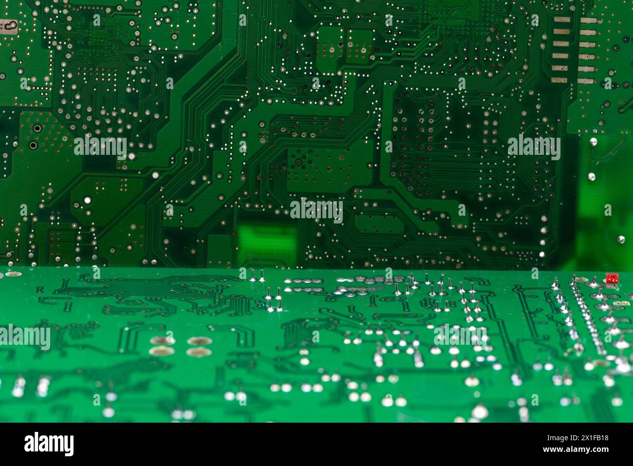 Detalle de múltiples de circuitos impresos de una placa electrónica de color verde Foto Stock