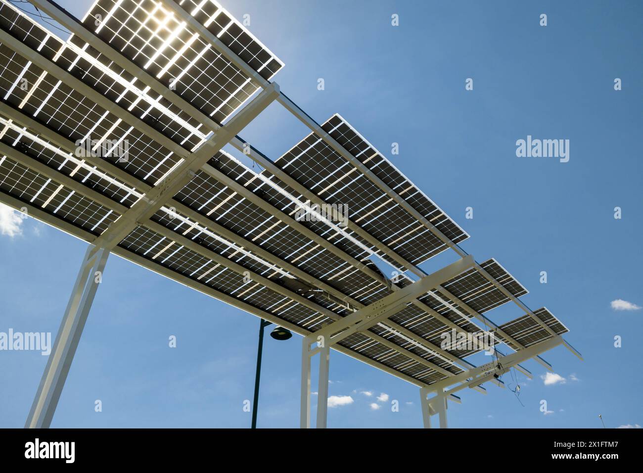 Fallimento della tecnologia fotovoltaica integrata nelle infrastrutture urbane. Danni causati dall'uragano causati dal vento ai pannelli solari installati come tetto ombreggiato sul parcheggio Foto Stock
