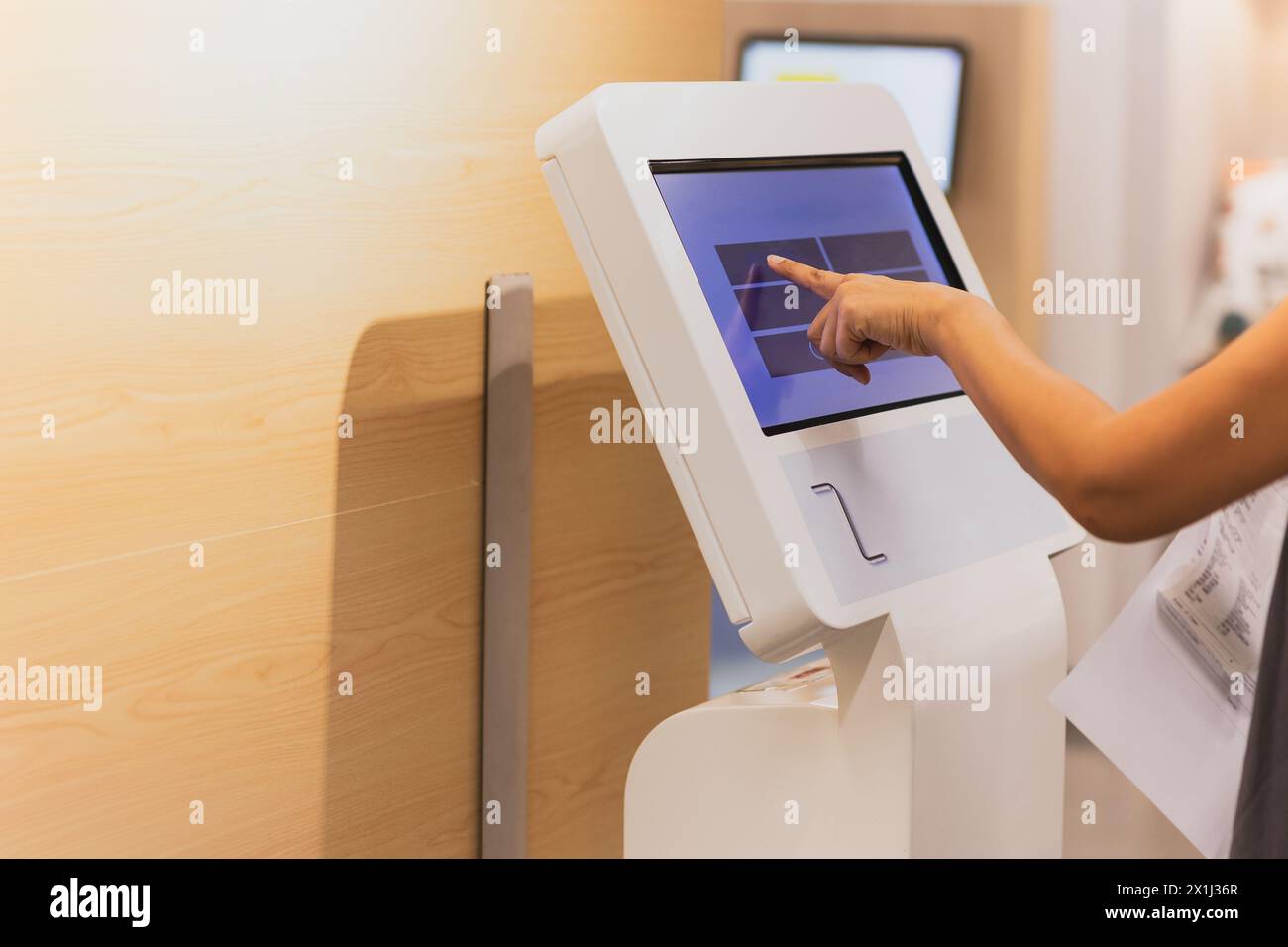 Donna con il dito monitor touch screen che cerca qualcosa nei grandi magazzini. Foto Stock