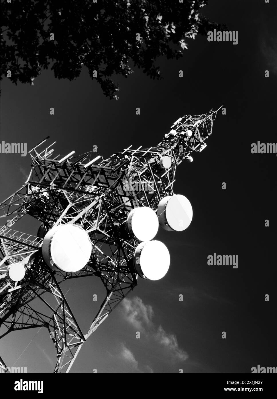 Montante per comunicazioni su strada con impianti di telecomunicazioni su sfondo scuro, Inghilterra, Regno Unito Foto Stock