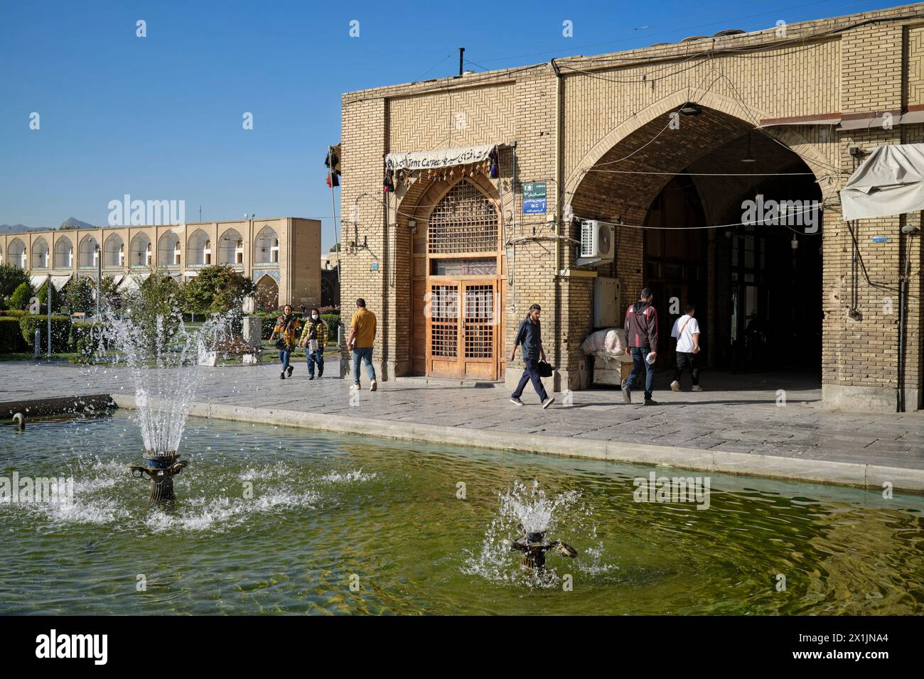 La gente cammina presso la fontana di Naqsh-e Jahan Square, sito patrimonio dell'umanità dell'UNESCO. Isfahan, Iran. Foto Stock