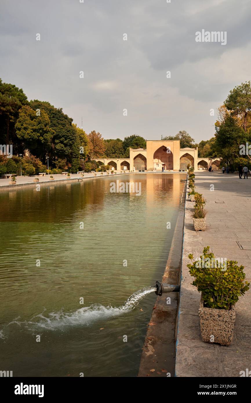 Piscina d'acqua nel giardino del Palazzo Chehel Sotoun del XVII secolo con cancello d'ingresso sullo sfondo. Isfahan, Iran. Foto Stock
