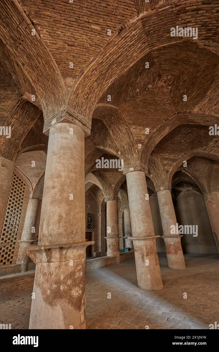 Vista interna della sala ipostila con molti pilastri che sostengono il tetto di volte in mattoni nella Moschea Jameh di Isfahan, Iran. Foto Stock