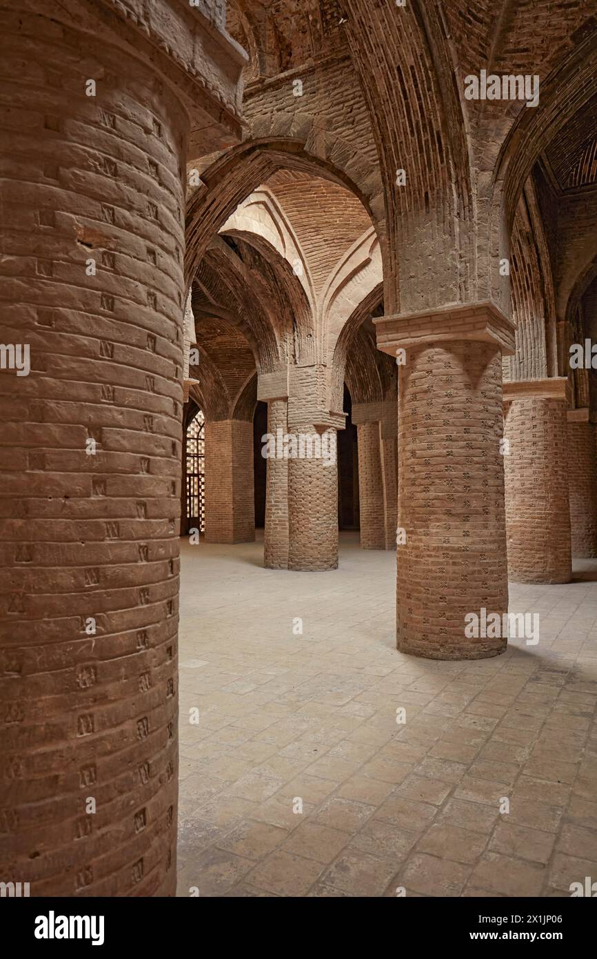 Vista interna della sala ipostila con molti pilastri che sostengono il tetto di volte in mattoni nella Moschea Jameh di Isfahan, Iran. Foto Stock