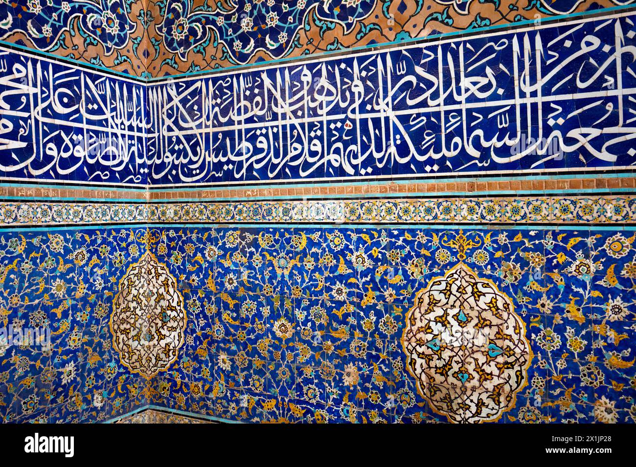 Vista ravvicinata di piastrelle altamente elaborate con motivi arabeschi e calligrafia coranica sulle pareti della Moschea dello Scià (Masjed-e Shah). Isfahan, Iran. Foto Stock