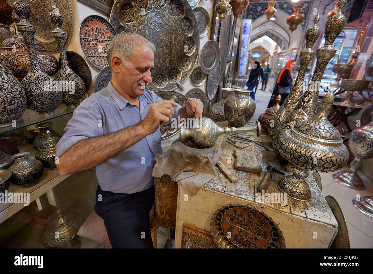 Qalamzani, o Ghalamzani (arte tradizionale iraniana dell'incisione del metallo), opera nel suo negozio di artigianato nel Grand Bazaar. Isfahan, Iran. Foto Stock