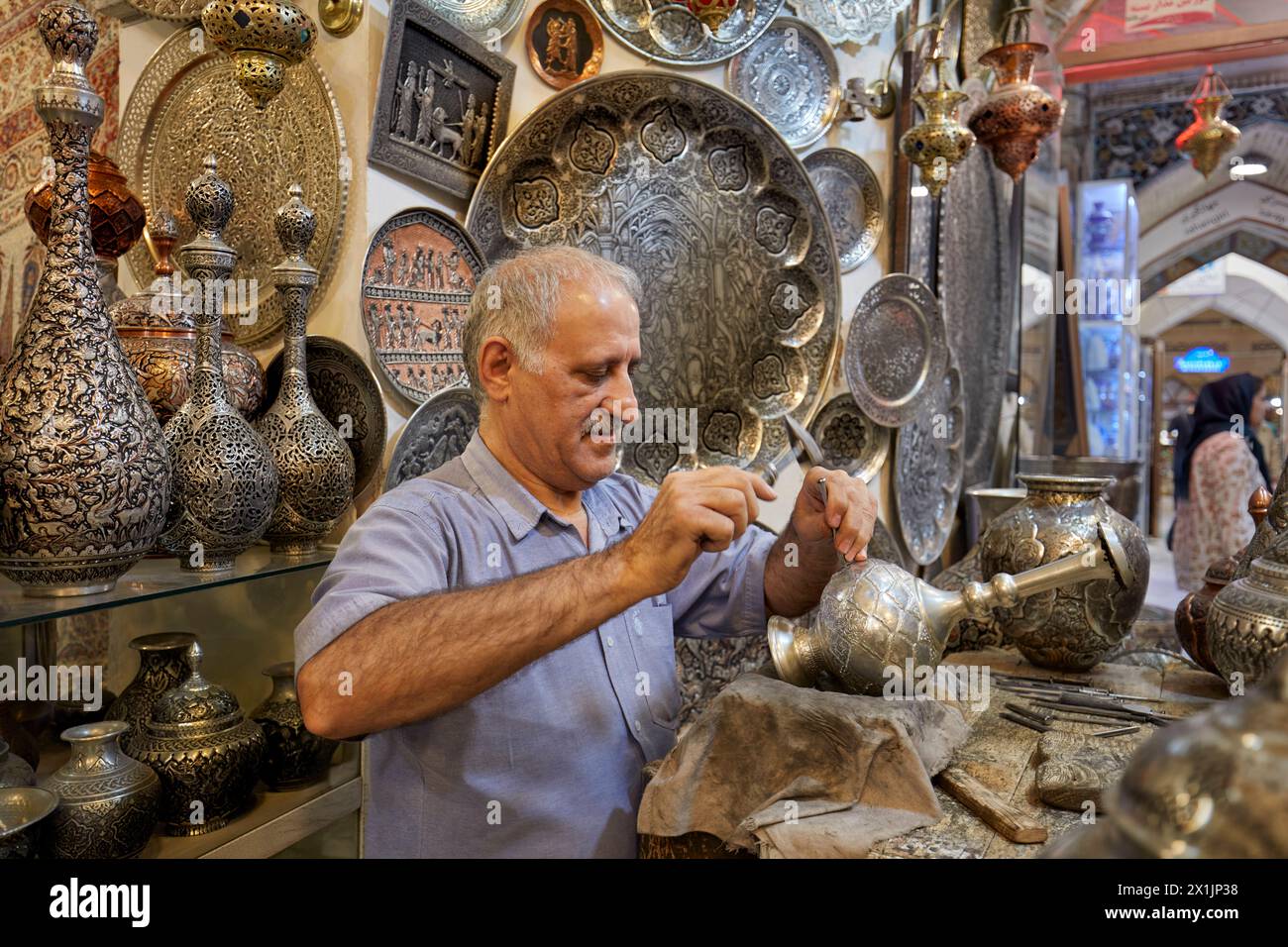 Qalamzani, o Ghalamzani (arte tradizionale iraniana dell'incisione del metallo), opera nel suo negozio di artigianato nel Grand Bazaar. Isfahan, Iran. Foto Stock