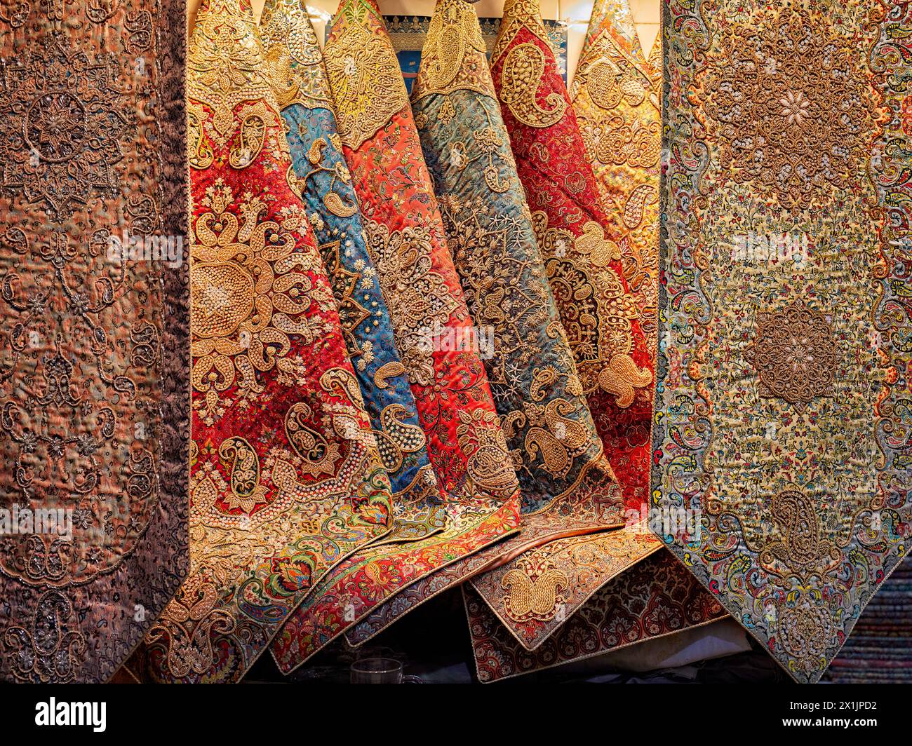 Selezione colorata di Termeh, tradizionale tessuto persiano lavorato a mano, ricamato con seta, esposto in un negozio di artigianato. Isfahan, Iran. Foto Stock