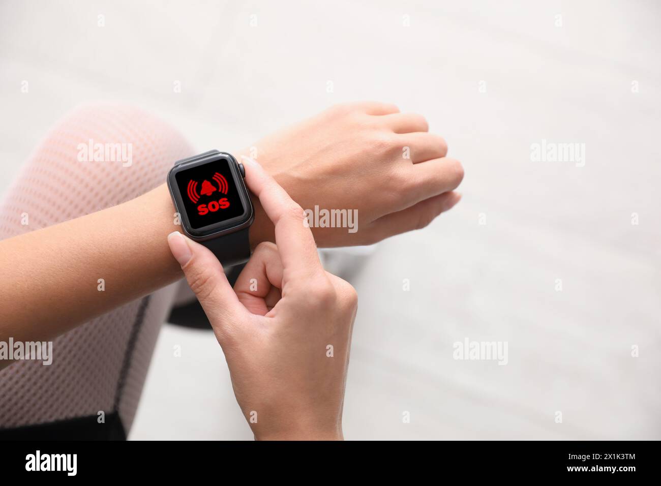 Donna che utilizza la funzione SOS su uno smartwatch all'aperto, primo piano Foto Stock