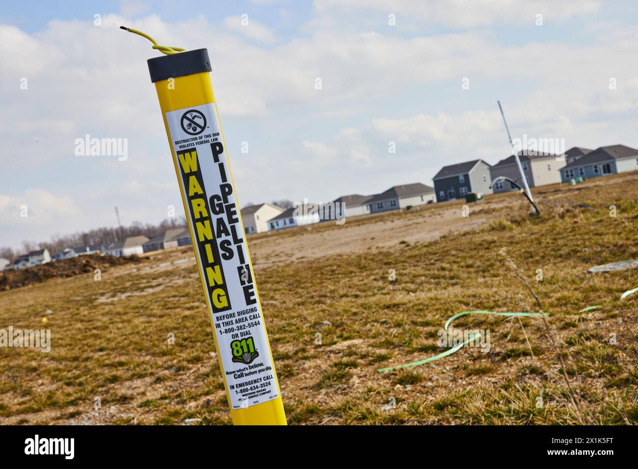 Marcatore di sicurezza per sviluppo suburbano e condotte, sfondo Clear Sky Foto Stock