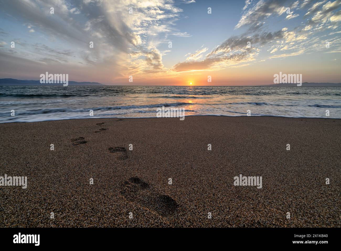 Footprints in the Sand con un ambiente Ocean Sunrise Landscape Foto Stock