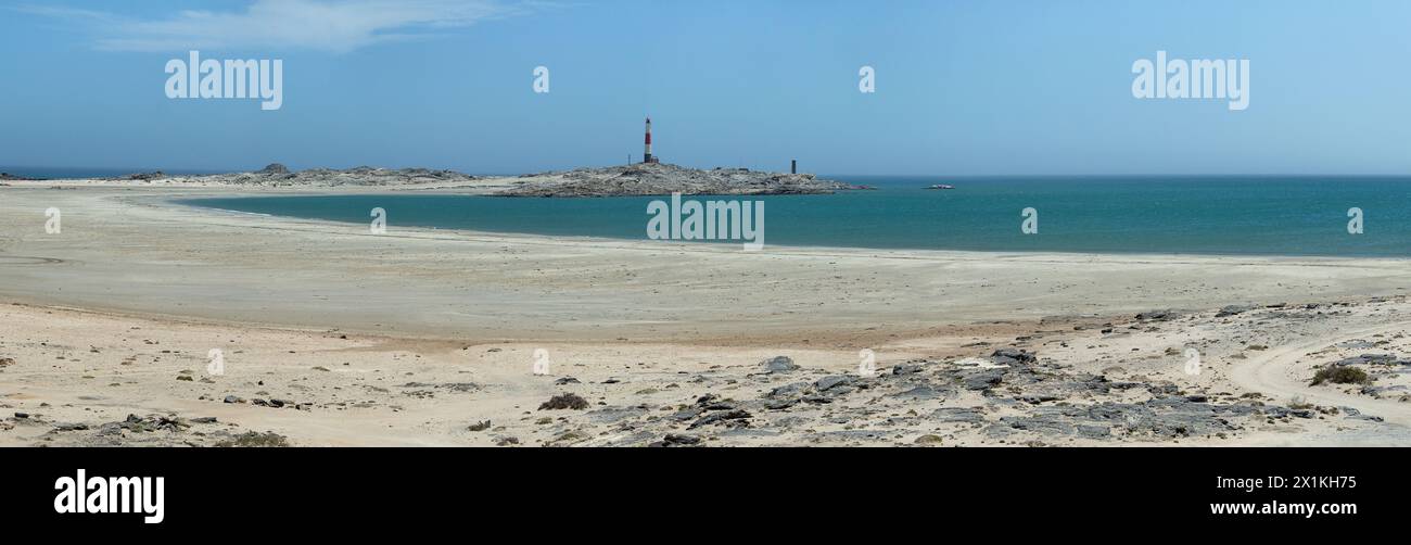 Un panorama della tranquilla baia deserta e sabbiosa e del faro di Diaz Point da oltre la baia, sulla penisola vicino a Luderitz, Namibia. Foto Stock