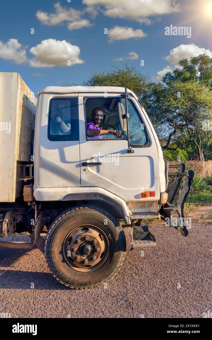 conducente africano nella cabina del veicolo , vista profilo, trasporto in città Foto Stock