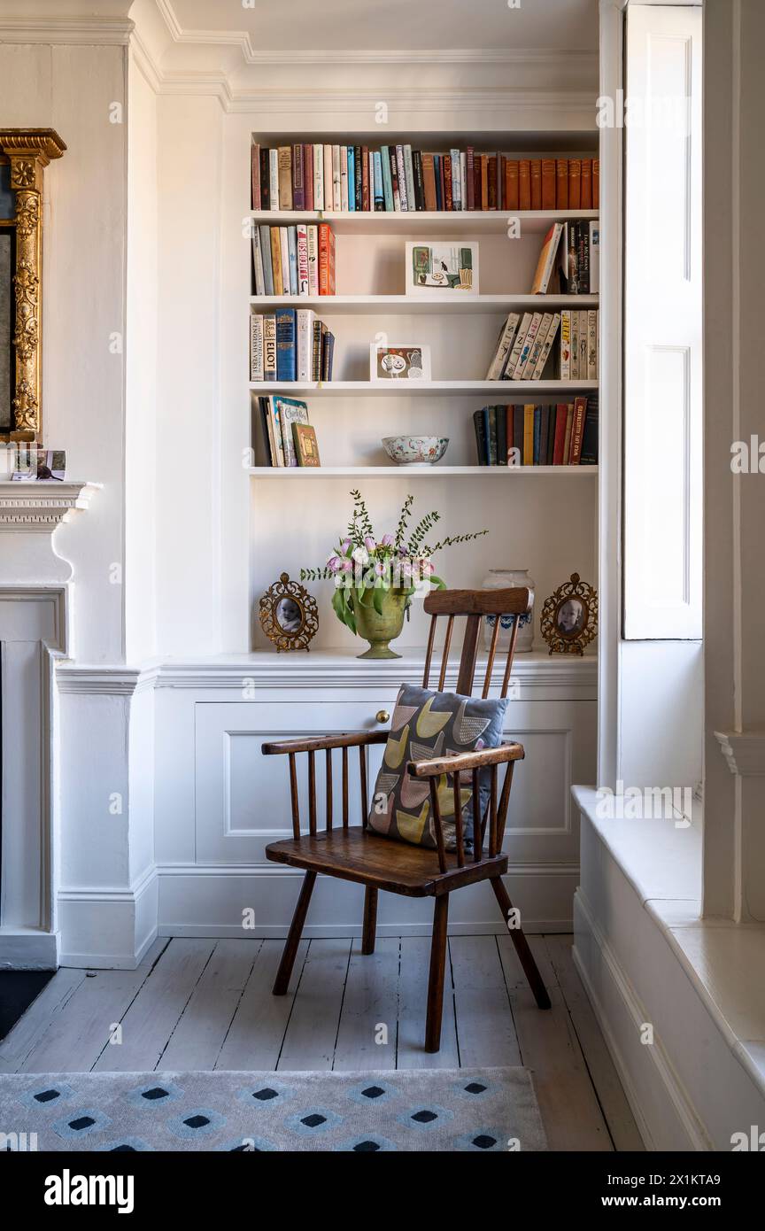 Sedia in legno vintage con scaffalature a libro incassate nella residenza georgiana di Greenwich, Londra, Regno Unito Foto Stock